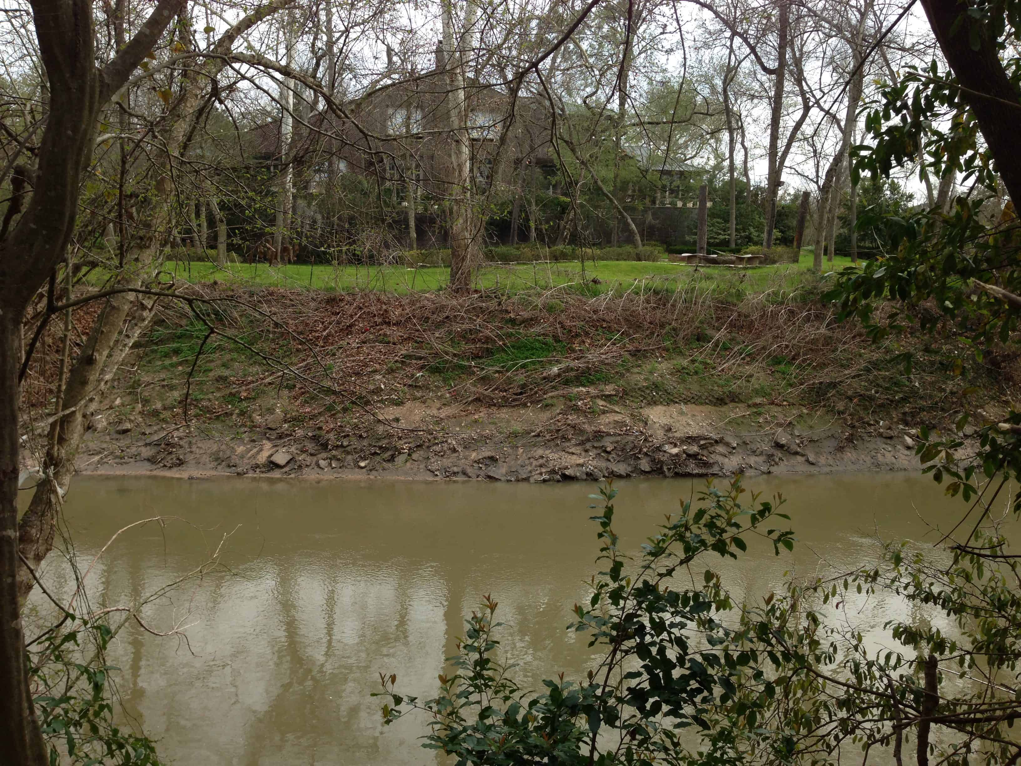 View of a River Oaks home backing to Buffalo Bayou from Memorial Park Houston TX