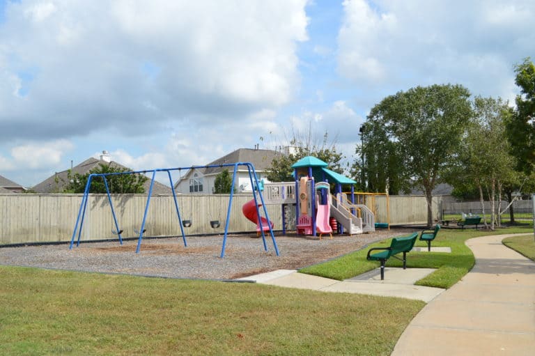 Playground with swings and a slide at the Sheffield community park, Houston TX 77095