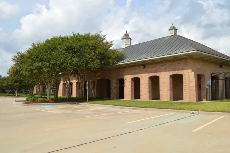 Sheffield brick pool pavilion with a metal hip roof and twin cupolas, Houston TX 77095