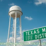 Texas water tower with a green road sign reading Texas MUD District