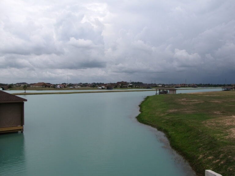 Lakefront homes and boathouses across a Lakes of Katy channel, Katy TX 77493