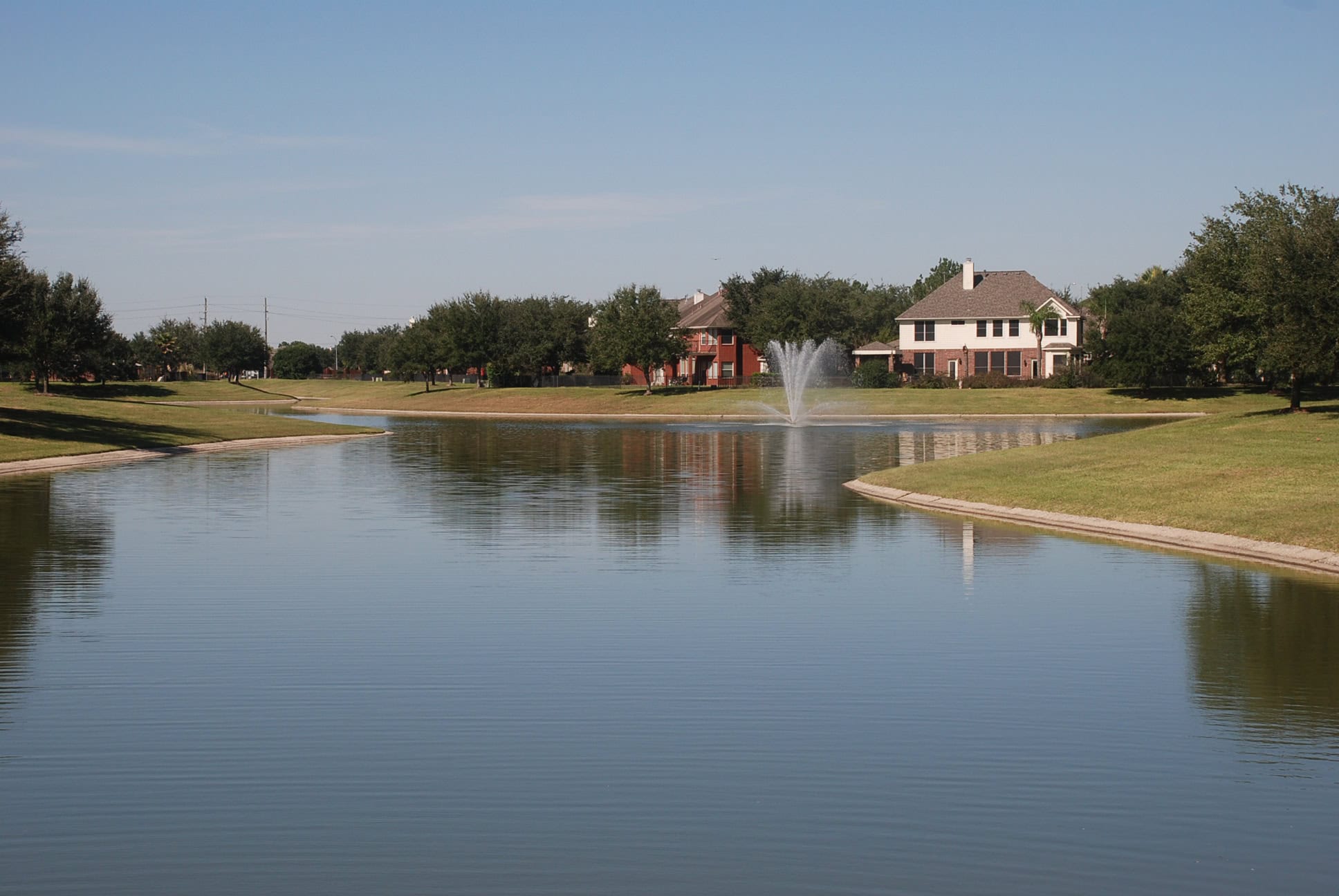 Stone Gate lake with a fountain and homes along the water, Houston TX 77095