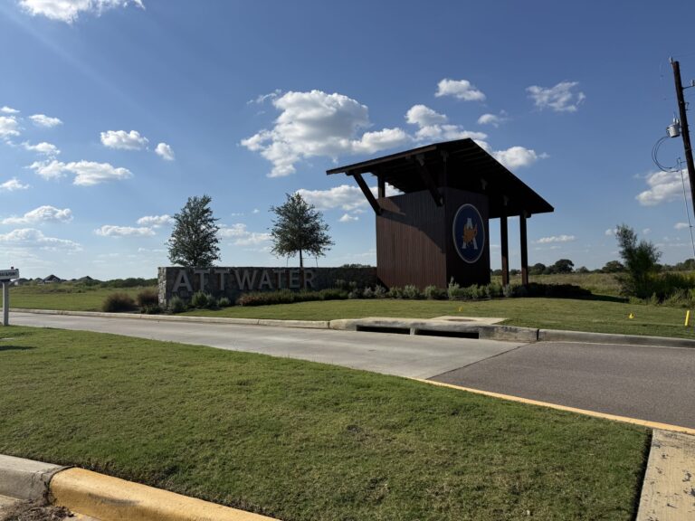The ATTWATER stone entry monument and timber tower with the community's prairie-chicken logo, Waller TX 77484