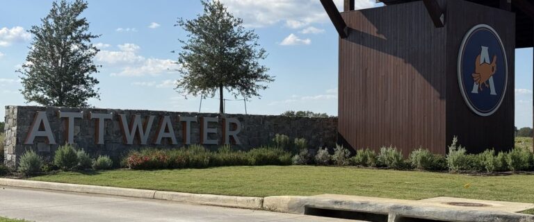 ATTWATER stone entry monument and timber tower with the community's prairie-chicken logo, Waller TX 77484