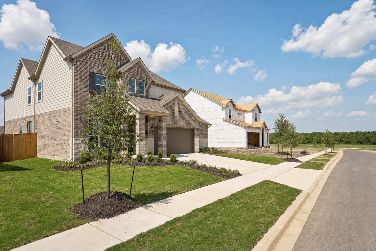 First-time home buyer in Hockley: a newly finished new-construction home beside a house under framing on a corridor street in Hockley, TX 77447
