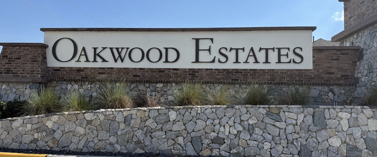OAKWOOD ESTATES entry sign on a brick and stone monument wall, Waller TX 77484