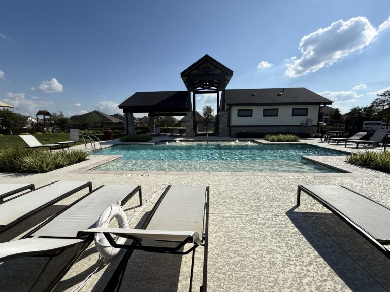 Oakwood Estates pool with lounge chairs, a covered pavilion and a pool house behind it, Waller TX 77484