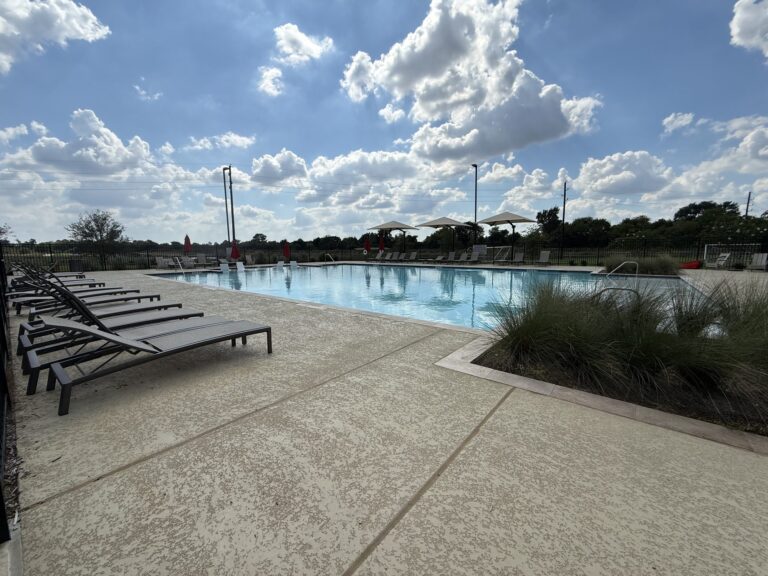 Pool deck with lounge chairs and shade umbrellas at the Redbud amenity center, Hockley TX 77447