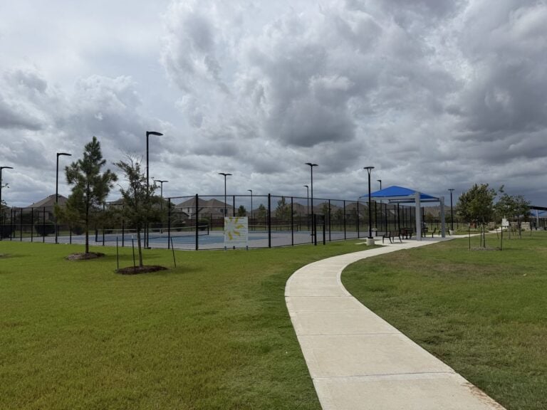 Tennis courts and a walking path at a Sunterra park, Katy TX 77493