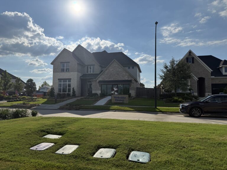 The Grand Prairie Welcome Center, a brick and stone home with a Welcome Center sign in the front lawn, Hockley TX 77447