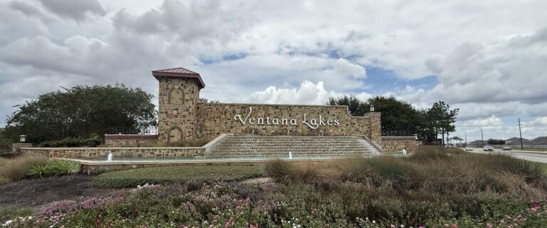 Ventana Lakes stone entry monument with a stepped water feature and flower beds, Katy TX 77493