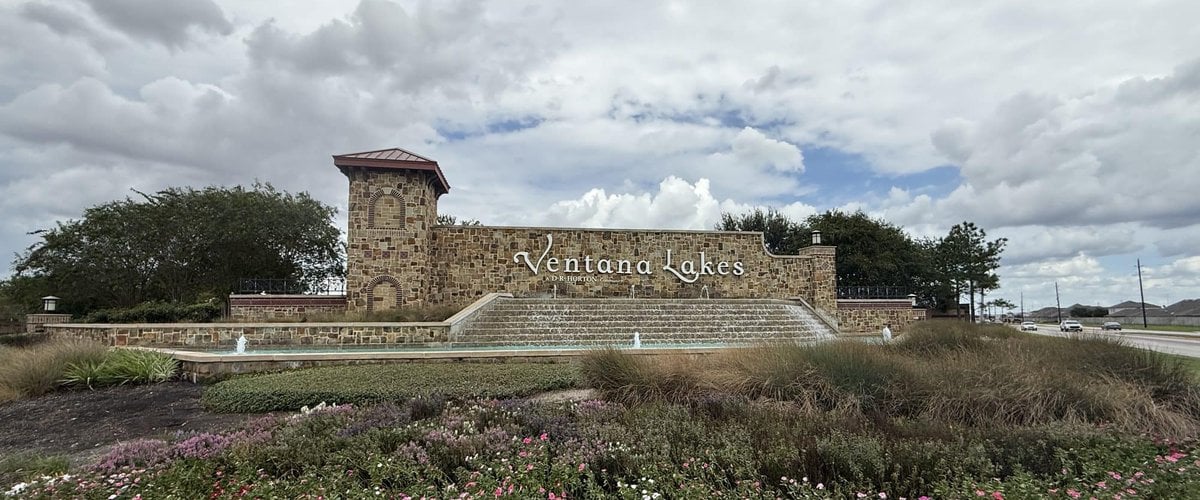 Ventana Lakes stone entry monument with a stepped water feature and flower beds, Katy TX 77493