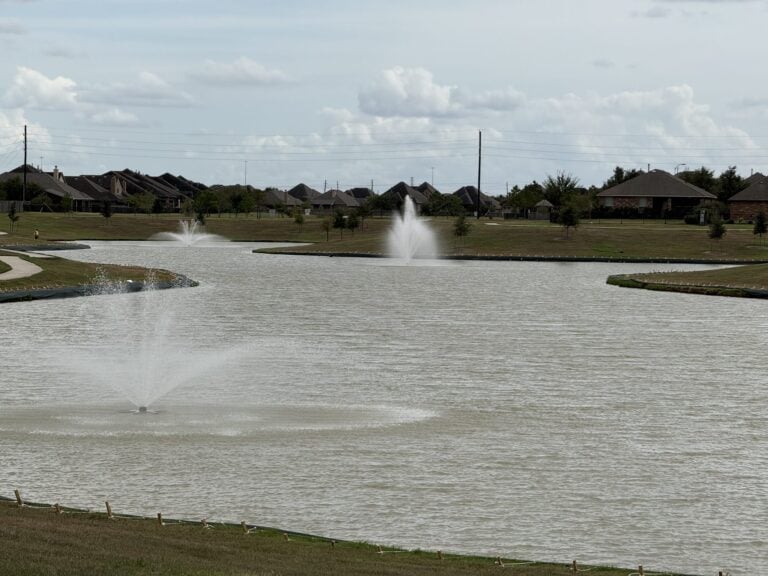 Lake with two fountains and homes along the far bank in Ventana Lakes, Katy TX 77493