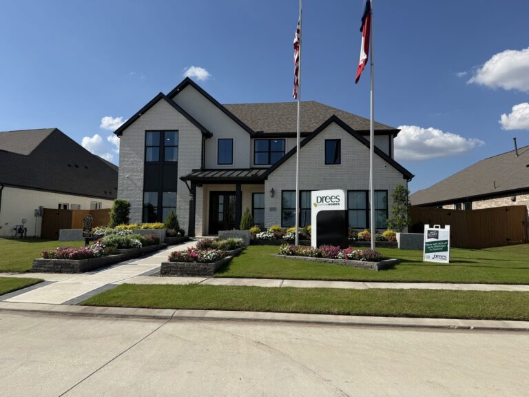 Two-story Drees Custom Homes model with a white brick front, black trim, and a flagpole, Wildrye, Waller TX 77484